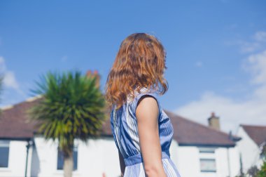 Bahçede duran genç bir kadın.