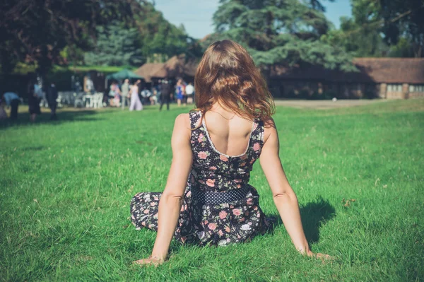 Vrouw ontspannen op gras op feestje — Stockfoto