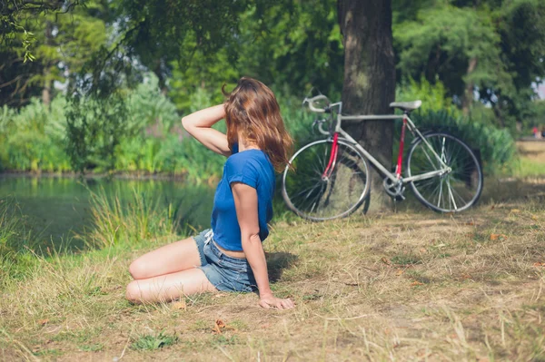 Young woman relaxing by water in the park — Stock Photo, Image