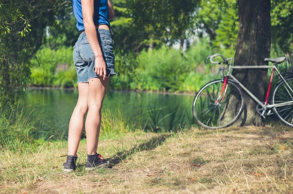 Jeune femme debout au bord de l'eau dans le parc — Photo