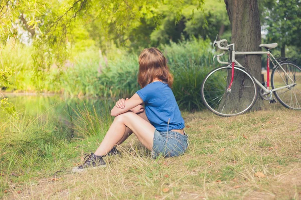 Jonge vrouw ontspannen door water in het park — Stockfoto