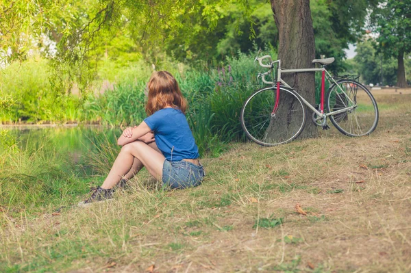 Young woman relaxing by water in the park — Stock Photo, Image