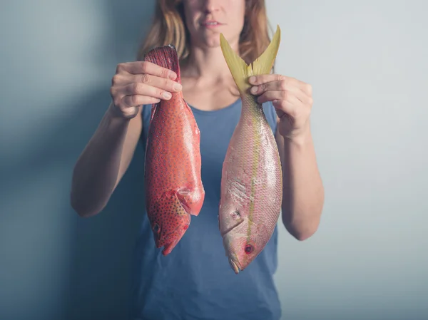 Jonge vrouw met exotische vissen — Stockfoto