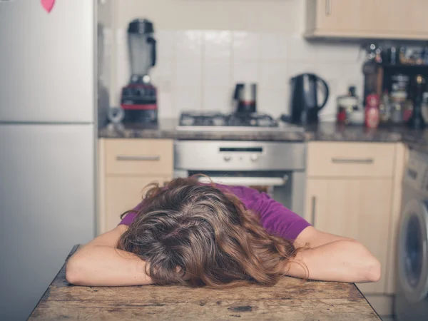 Жінка спить за столом на кухні — стокове фото