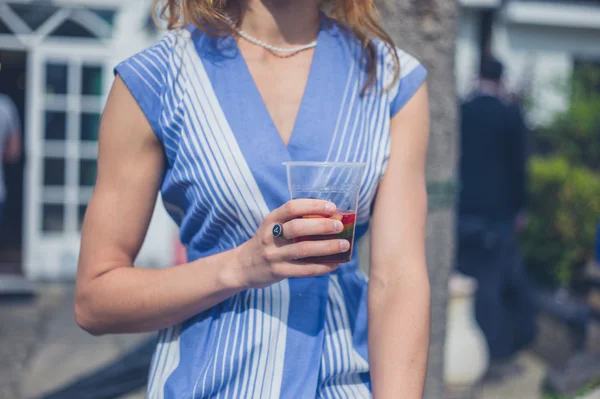 Jeune femme relaxante avec boisson dans le jardin — Photo