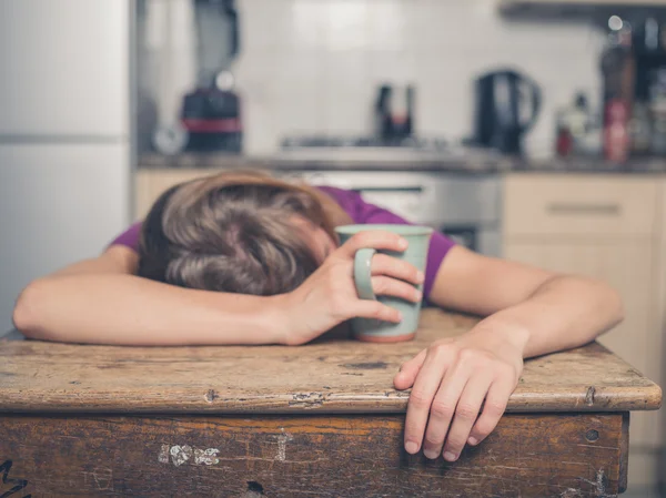 Mujer cansada con té en la cocina — Foto de Stock