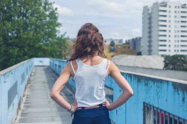 Bir yaya köprüsü üzerinde duran genç kadın