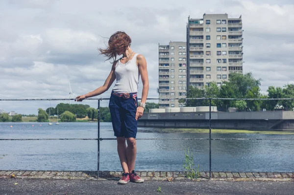Yanında deniz ile ilgili kentsel alanda duran genç kadın — Stok fotoğraf