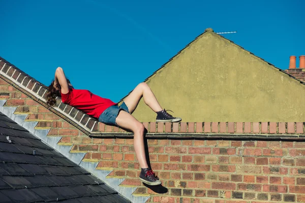 Young woman lying on a roof — Stock Photo, Image