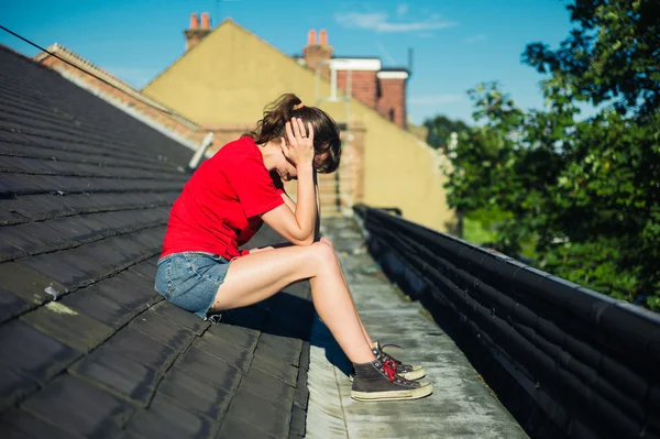 Bir çatıda oturan üzgün genç kadın — Stok fotoğraf