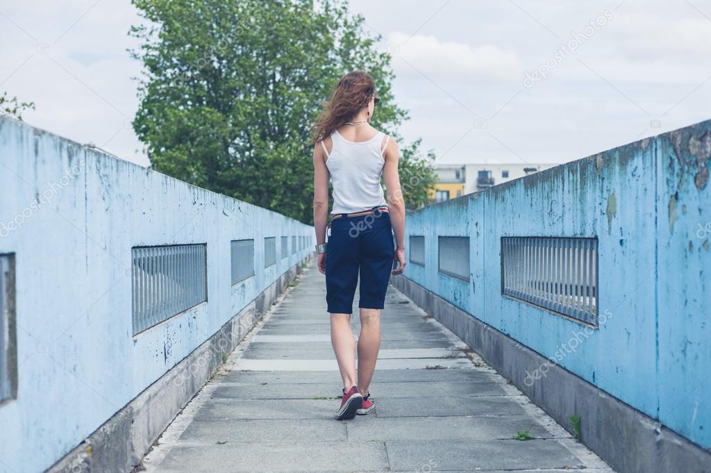 Young woman walking on a foot bridge