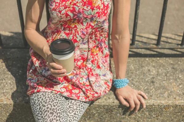 Yougn mulher sentada lá fora com uma xícara de café — Fotografia de Stock