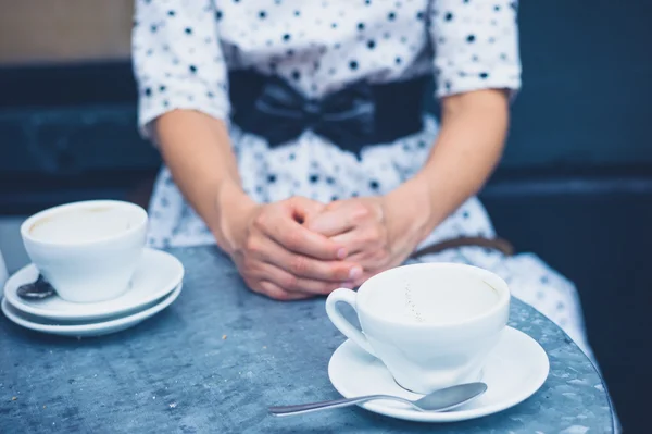 Женщина за столом с пустыми кофейными чашками — стоковое фото