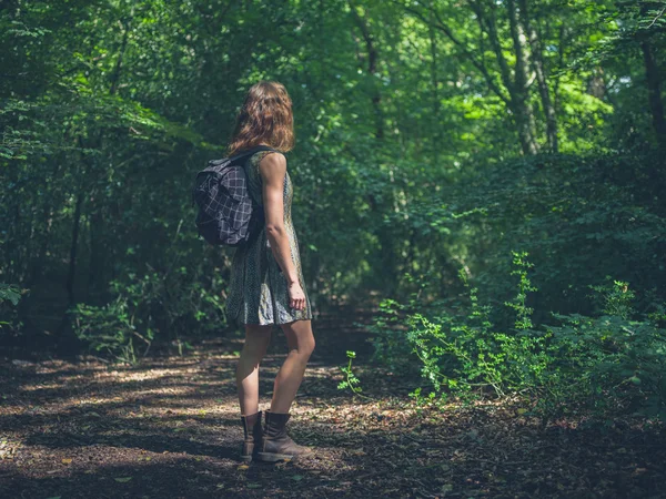 Vrouw met rugzak in bos — Stockfoto