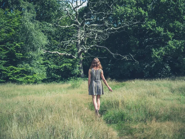 Jeune femme marchant dans la prairie — Photo