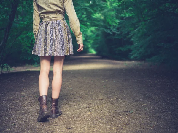 Mujer joven caminando por la carretera en el bosque —  Fotos de Stock