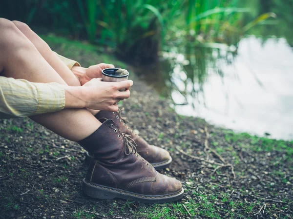 Frau trinkt Tee am Teich im Wald — Stockfoto