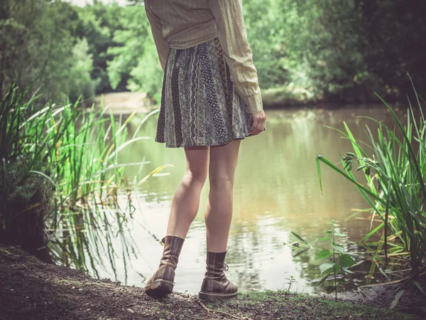 Junge Frau steht am Teich im Wald — Stockfoto