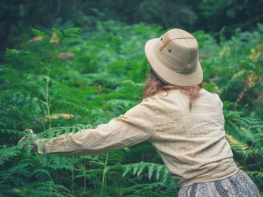 Genç kadın kalın orman keşfetmek