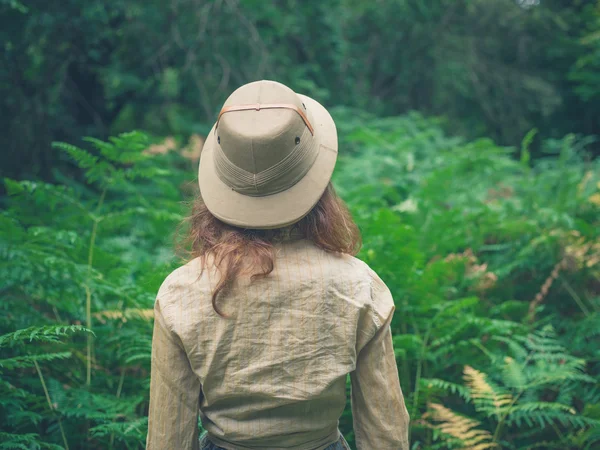 Mujer joven explorando bosque grueso — Foto de Stock