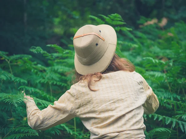 Jonge vrouw verkennen dikke bos — Stockfoto