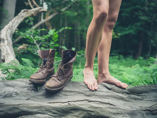Ormandaki düşmüş ağaç üzerinde çıplak ayak kadınla