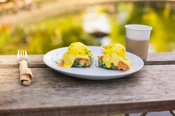 Huevos benedictos en un plato en el parque — Foto de Stock