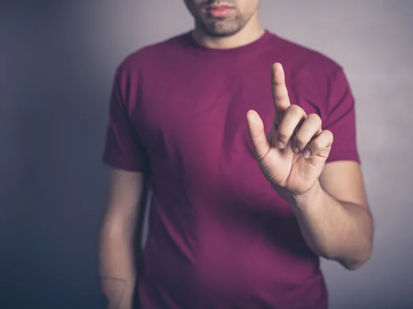 Young man raising his finger — Stock Photo, Image