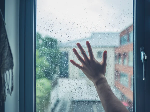年轻的男人用手抚摸窗口与露水 — 图库照片