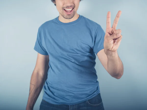 Happy young man showing victory sign — Stock Photo, Image