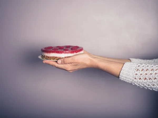 Manos femeninas sosteniendo un pastel de queso —  Fotos de Stock