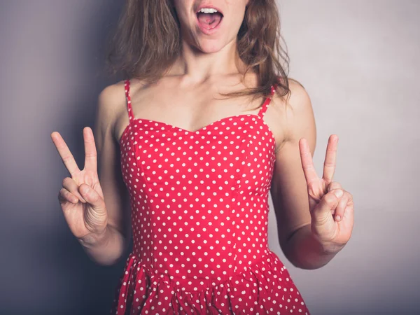 Mujer joven mostrando signos de victoria — Foto de Stock