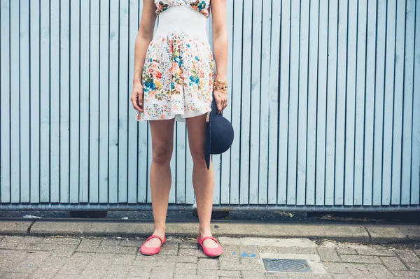 Mujer en vestido con sombrero exterior por cerca azul —  Fotos de Stock