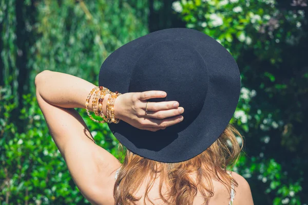 Mujer joven con sombrero caminando en la naturaleza —  Fotos de Stock