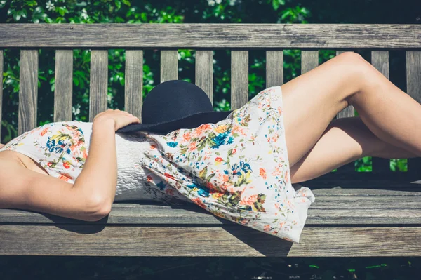 Jeune femme se détendre sur le banc dans le parc — Photo