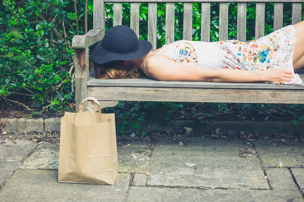 Jeune femme se détendre sur le banc dans le parc — Photo