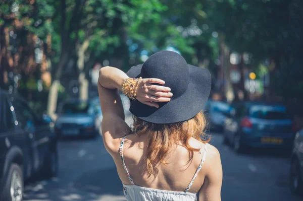 Young woman with hat walking in the street — Stock Photo, Image