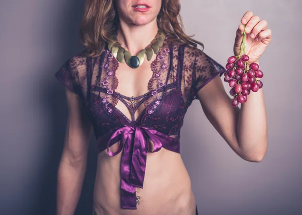 Сексуальна молода жінка в екзотичній білизні з виноградом Ліцензійні Стокові Зображення