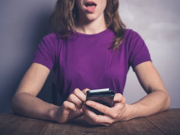 Junge Frau mit Smartphone überrascht — Stockfoto