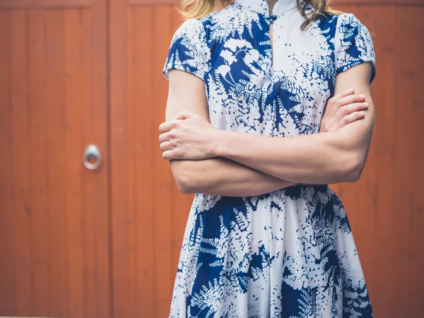 Vrouw met gekruiste door oranje poort armen — Stockfoto