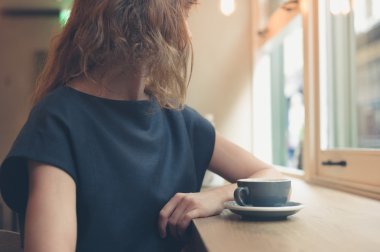 Pencere kafede kahve olan kadın