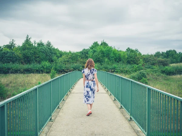 国の歩道橋の上を歩く女性 — ストック写真