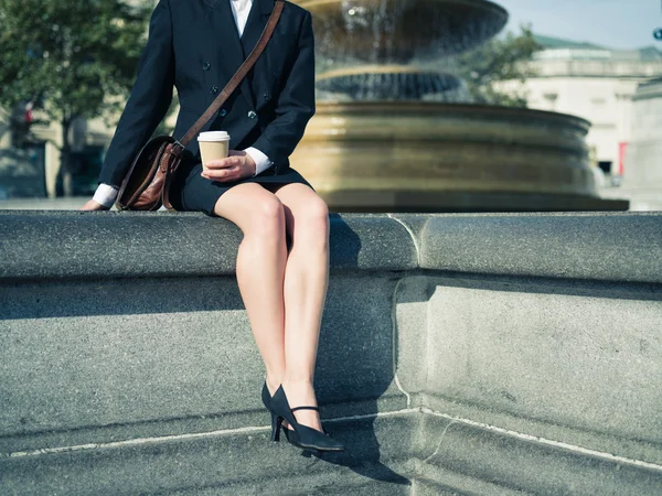 Young businesswoman with coffee by fountain — Stock Photo, Image