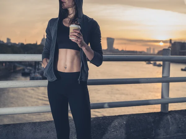 Athletic young woman with cup in London at sunrise — Zdjęcie stockowe