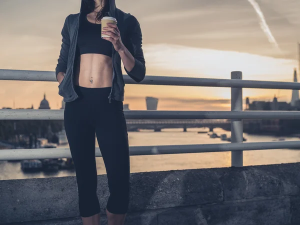 Athletic young woman with cup in London at sunrise — Zdjęcie stockowe