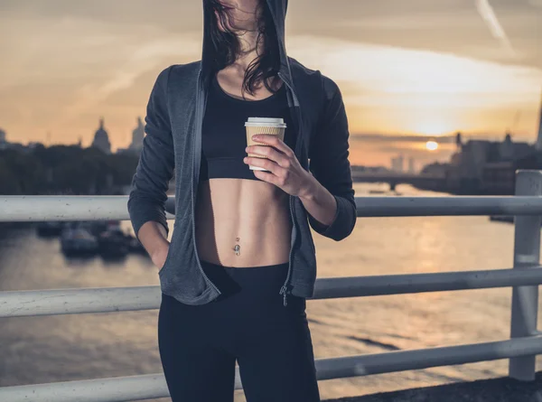 Athletic young woman with cup in London at sunrise — ストック写真