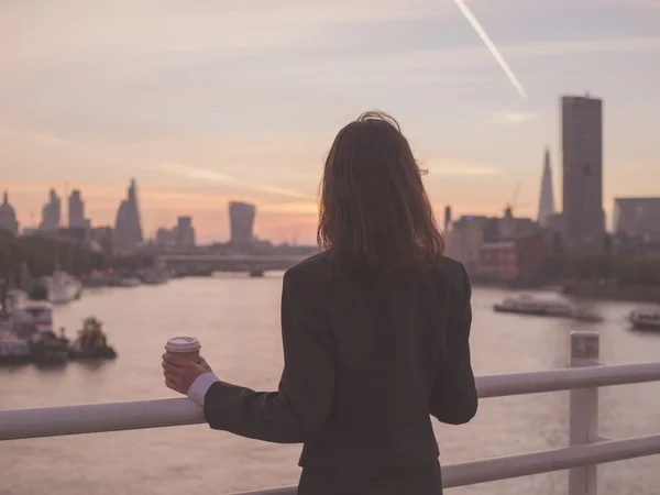 Businesswoman with cup admiring sunrise in London — Stok fotoğraf