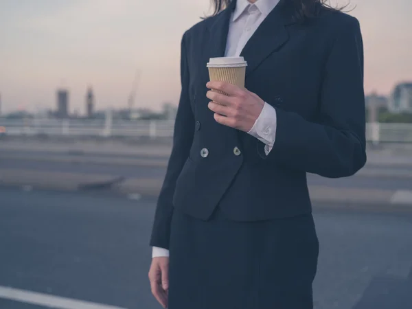 Young businesswoman at sunrise with cup — Stock fotografie