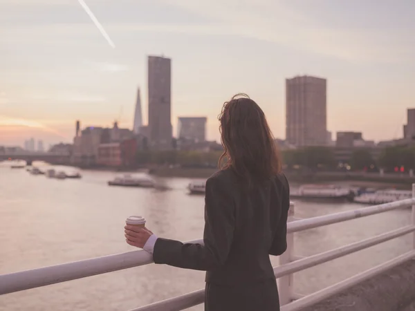 Businesswoman with cup admiring sunrise in London — Zdjęcie stockowe