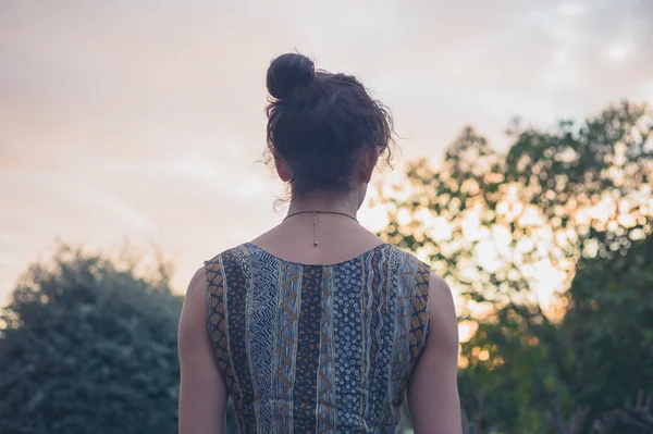 Achteraanzicht van jonge vrouw bij zonsondergang — Stockfoto